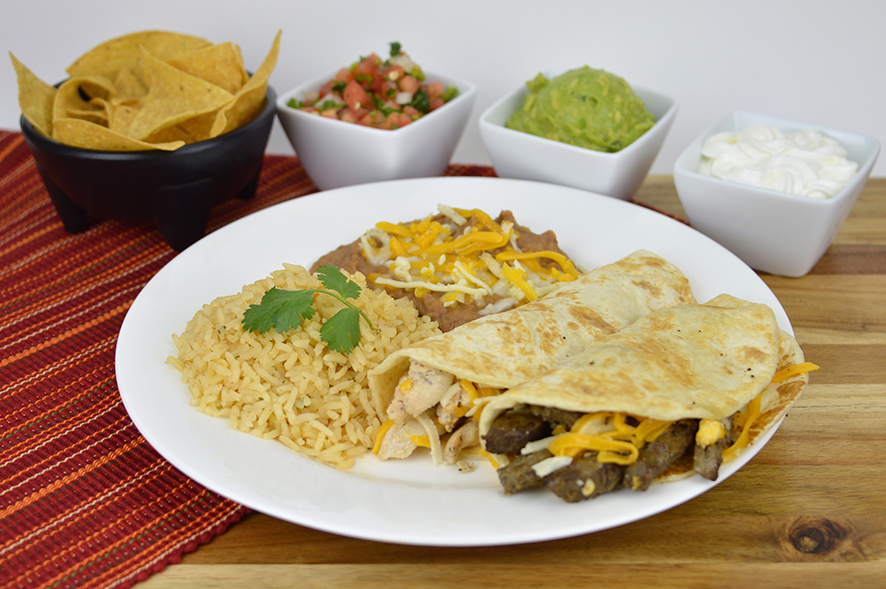 Sizzling fajita platter with peppers, tortillas, and sides